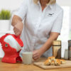 Lady using the tilt-to-pour action of the red and white Uccello Kettle