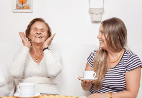 Mother and daughter laughing over tea