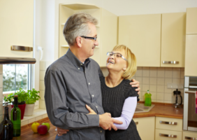 Caring Wife hugs her husband in the kitchen