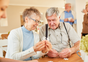 Elderly woman completing a jigsaw with an elderly man