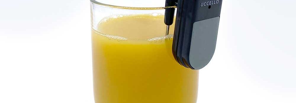 Uccello Liquid Level Indicator on the lip of a glass of orange juice