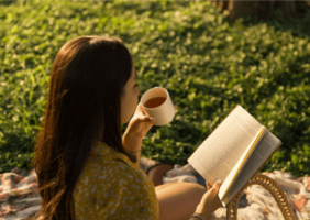 Woman reading outside with a cup of tea on a hot day