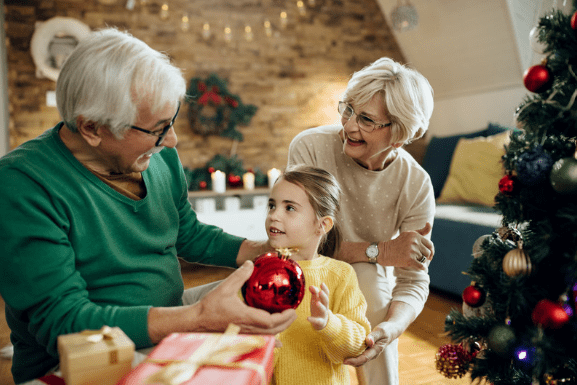 Grandparents decorating the Christmas tree with Grandchild