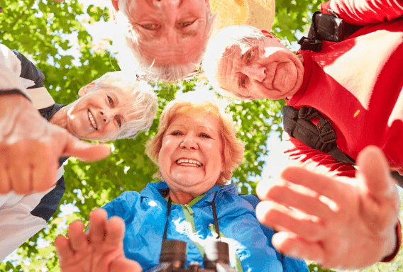 Elderly people huddles around a camera on a sunny day