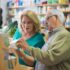 Elderly man holding a box talking to elderly woman