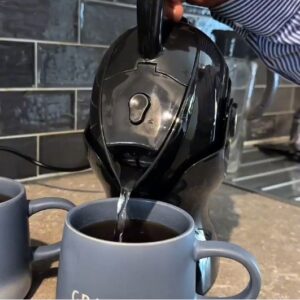 Elderly man pouring the all black Uccello Kettle to make tea