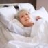 Elderly woman stretching in her bed
