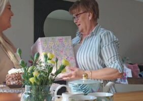 Adult daughter gifting her Mother's a large gift this Mother's Day